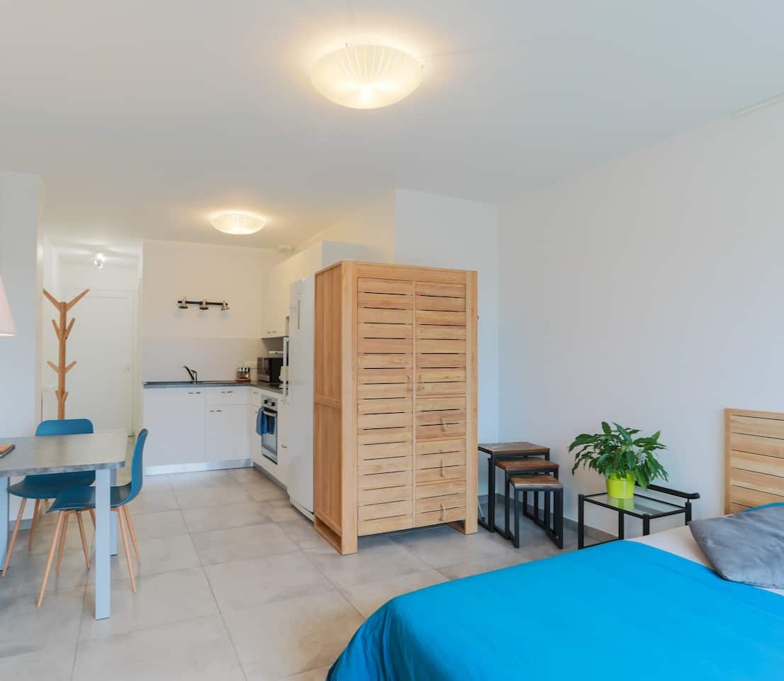 Intérieur lumineux du Studio Panorama : lit, coin repas et cuisine équipée